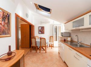 a kitchen and dining room with a table and chairs at Apartments Roda in Supetar