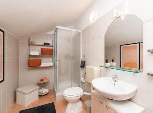 a bathroom with a toilet and a sink and a shower at Apartments Roda in Supetar