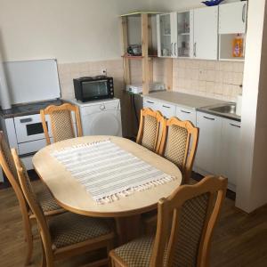 a kitchen with a table and chairs and a kitchen with a counter at Smještaj Klekovača in Drvar +21 photos