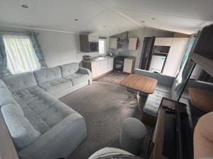 a living room with a couch and a kitchen at Explorer45 in Lytchett Minster +10 photos