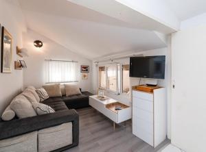 a living room with a couch and a flat screen tv at Apartments Roda in Supetar
