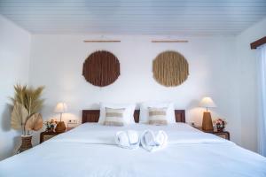 a bedroom with a white bed with white shoes on it at Pondok Bingin Guest House in Bingin Beach