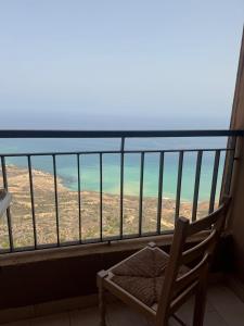a chair on a balcony with a view of the desert at Harmony immo in Bir el Djir +2 photos