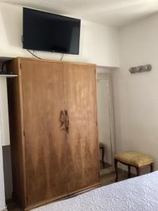 a bedroom with a wooden cabinet with a flat screen tv on the wall at Alle Fucine in Mallare