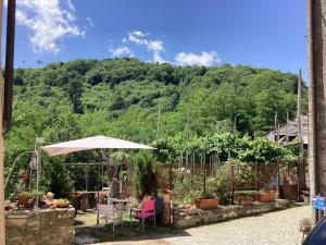 a patio with a table and an umbrella at Alle Fucine in Mallare