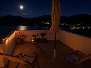 a balcony with a table and chairs at night at The Red-Fish House in Astypalaia