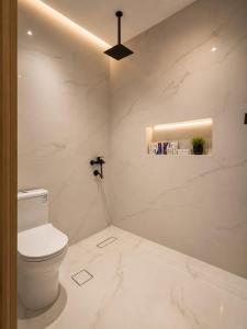 ein weißes Badezimmer mit Toilette und Decke in der Unterkunft رأس الشفا - OrbitNet in Al Shafa