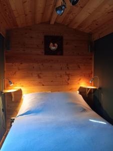 a bedroom with a bed with two lights on it at Notre roulotte de charme in Chevinay