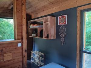 a room with a blue wall with a shelf at Notre roulotte de charme in Chevinay