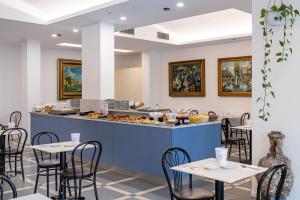 ein Restaurant mit Tischen und einer Theke mit Speisen in der Unterkunft Hotel Piccolo in Verona