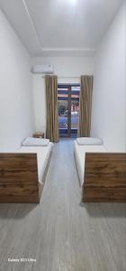 a bedroom with two beds and a large window at Magnato Hostel in Andizhan