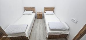 three beds in a room with white walls at Magnato Hostel in Andizhan +7 photos
