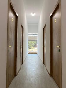 a corridor of a hallway with wooden doors at Magnato Hostel in Andizhan
