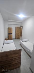 a bedroom with two beds and two wooden doors at Magnato Hostel in Andizhan