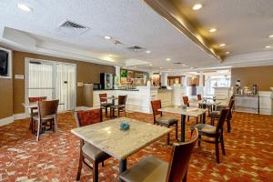 a restaurant with tables and chairs and a kitchen at Quality Suites San Antonio Northeast in San Antonio