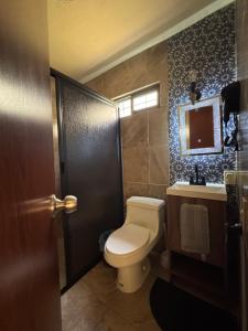 a bathroom with a toilet and a sink and a mirror at Casa MARTINA in Villahermosa