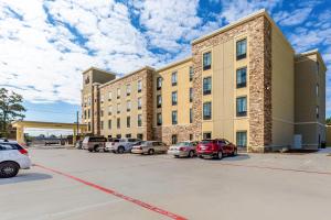 a large building with cars parked in a parking lot at Comfort Suites Channelview - Houston East in Channelview
