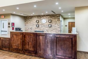 a lobby with a wooden bar with a brick wall at Comfort Suites Channelview - Houston East in Channelview