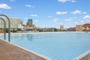 a large swimming pool with a city in the background at Luxurious Penthouse Pattaya in Pattaya South