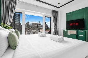 a bedroom with a large white bed with towels on it at Luxurious Penthouse Pattaya in Pattaya South