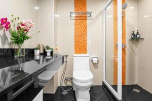 a bathroom with a toilet and a counter with flowers at Luxurious Penthouse Pattaya in Pattaya South +11 photos