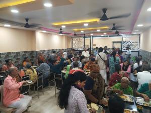 a crowd of people sitting at tables in a room at Meeraa Residency in Rāmeswaram