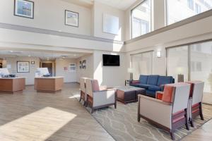 a waiting room with a blue couch and chairs at Comfort Inn & Suites Wichita Northeast in Wichita