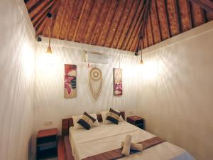 a bedroom with a bed and a wooden ceiling at Lombok eco Bungalow in Gili Gede