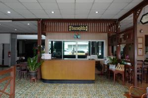 a restaurant with a counter and tables and chairs at โรงแรมยุติชัย in Prachuap Khiri Khan