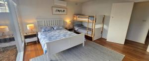 a bedroom with a bed and two bunk beds at The 20th Hole in Point Lonsdale