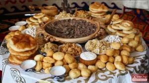a table with a bunch of different types of pastries at Sun Garden Guest House in Ak-Say