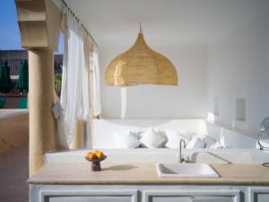 a kitchen with a sink and a bowl of fruit on a counter at Riad Tizwa Marrakech in Marrakesh