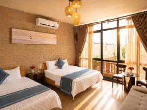 a hotel room with two beds and a balcony at Tình's Homestay in Ninh Binh