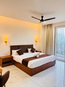 a bedroom with a large bed with a ceiling fan at Hotel janki elite in Jaipur
