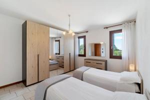 a bedroom with two beds and a mirror at Fattoria I Canarini - Biolago in Fossalta di Piave