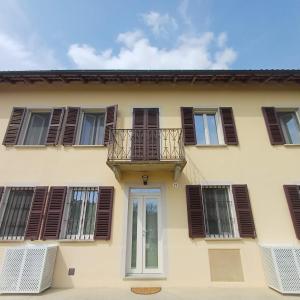 a building with brown shuttered windows and a balcony at B&B La RU in Montemagno