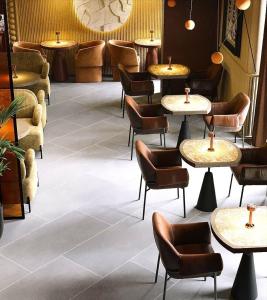 a restaurant with tables and chairs in a room at Urban Hotel Ethno in Bishkek