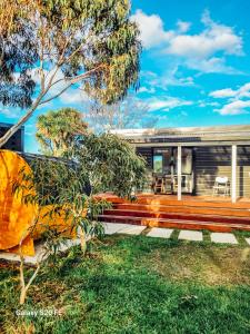 a house with a bench in the yard at The She Oak in Carterton