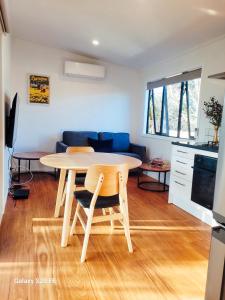 a living room with a table and a blue couch at The She Oak in Carterton