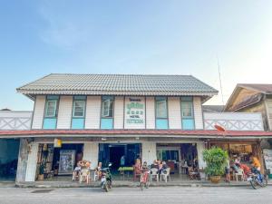 a building with people sitting outside of it at โรงแรมยุติชัย in Prachuap Khiri Khan
