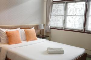 a bedroom with two beds and a window at โรงแรมยุติชัย in Prachuap Khiri Khan