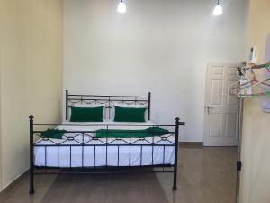 a bedroom with a bed with green pillows at Dee Holidays - in Moratuwa