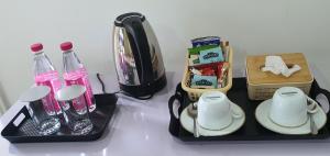 a table with two black trays with bottles and cups at Dee Holidays - in Moratuwa