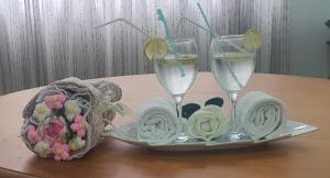 a table with two glasses of water and towels at Dee Holidays - in Moratuwa