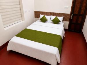 a bedroom with two beds with green and white sheets at Canorix Inn in Athirappilly