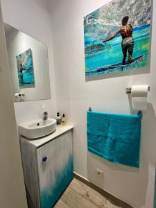 a bathroom with a sink and a painting on the wall at Centre Ville Fare Vairahi in Uturoa +17 photos
