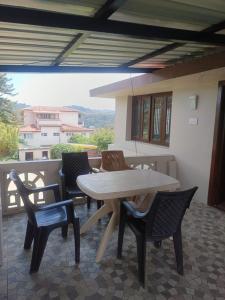 a wooden table and chairs on a patio at Kodai blue residency in Kodaikānāl