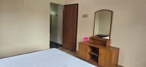 a bedroom with a mirror and a bed and a dresser at Kodai blue residency in Kodaikānāl