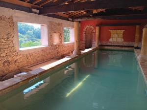 a pool of water in a building with windows at Notre yourte mongole in Chevinay