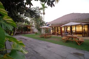 a resort with picnic tables and umbrellas in the grass at KU Villas in Kuta Lombok